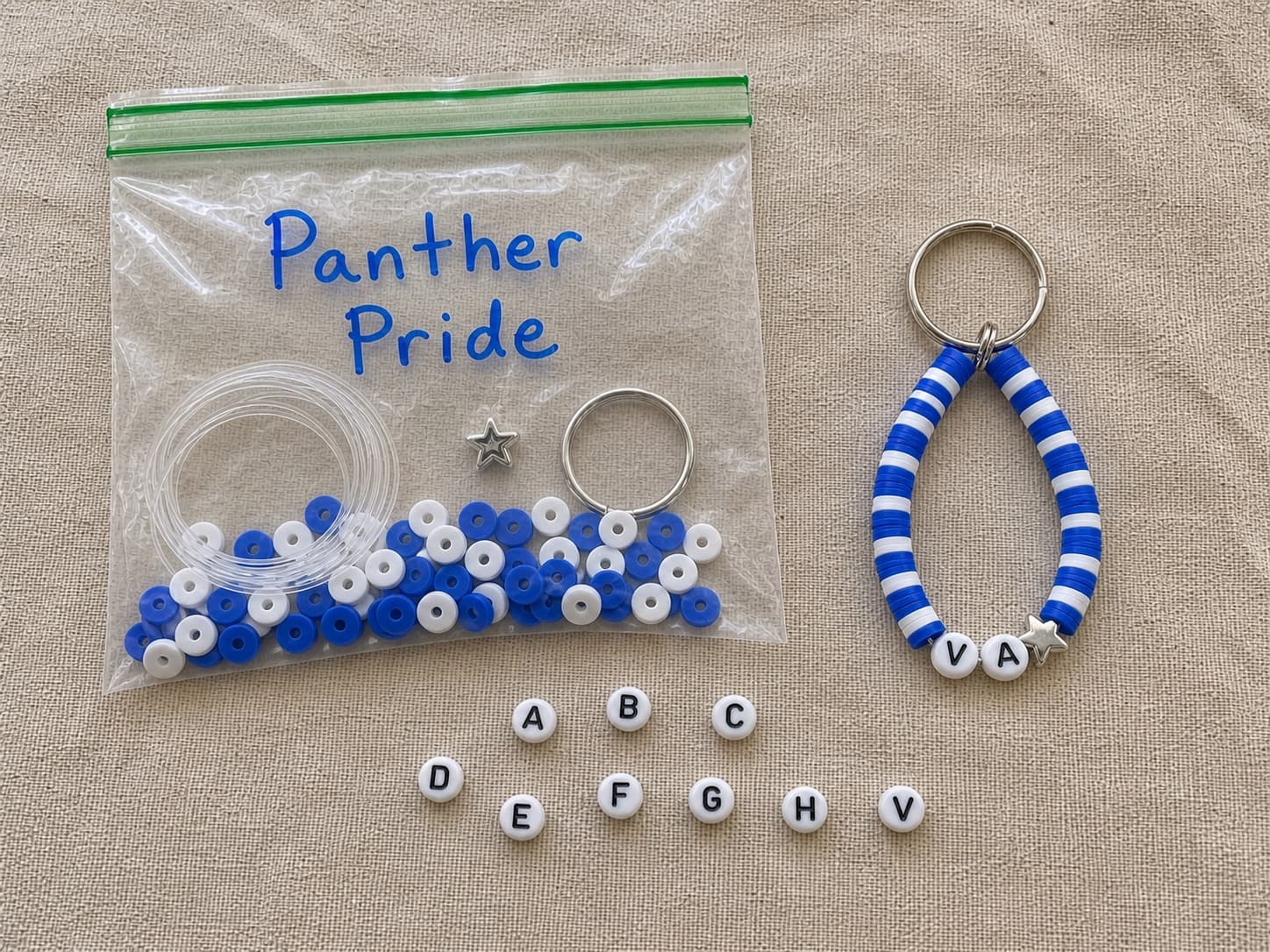 Finished royal blue and white VA keychain beside its clear DIY bead kit and loose alphabet beads