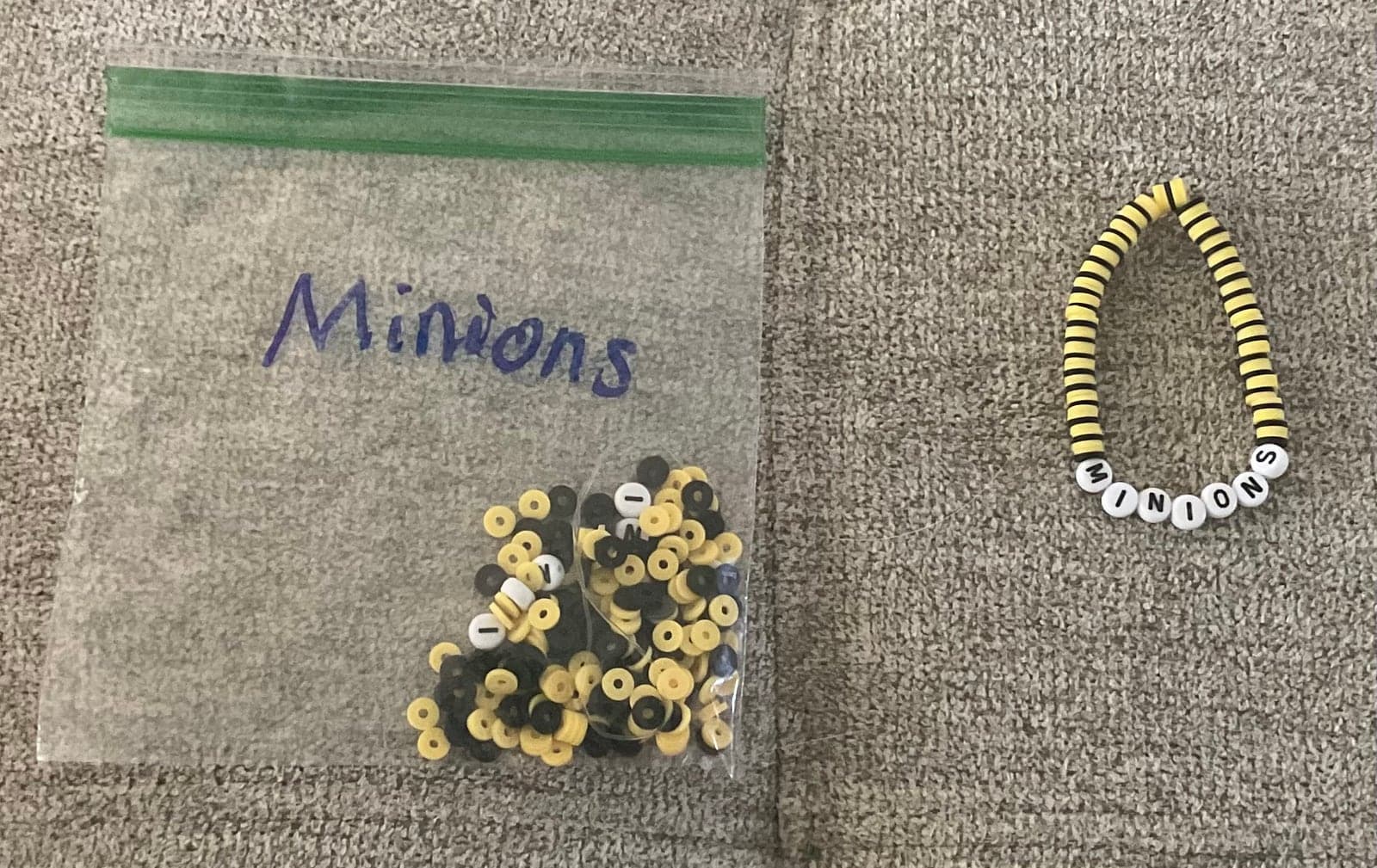 Yellow and black beads beside a handmade letter bracelet